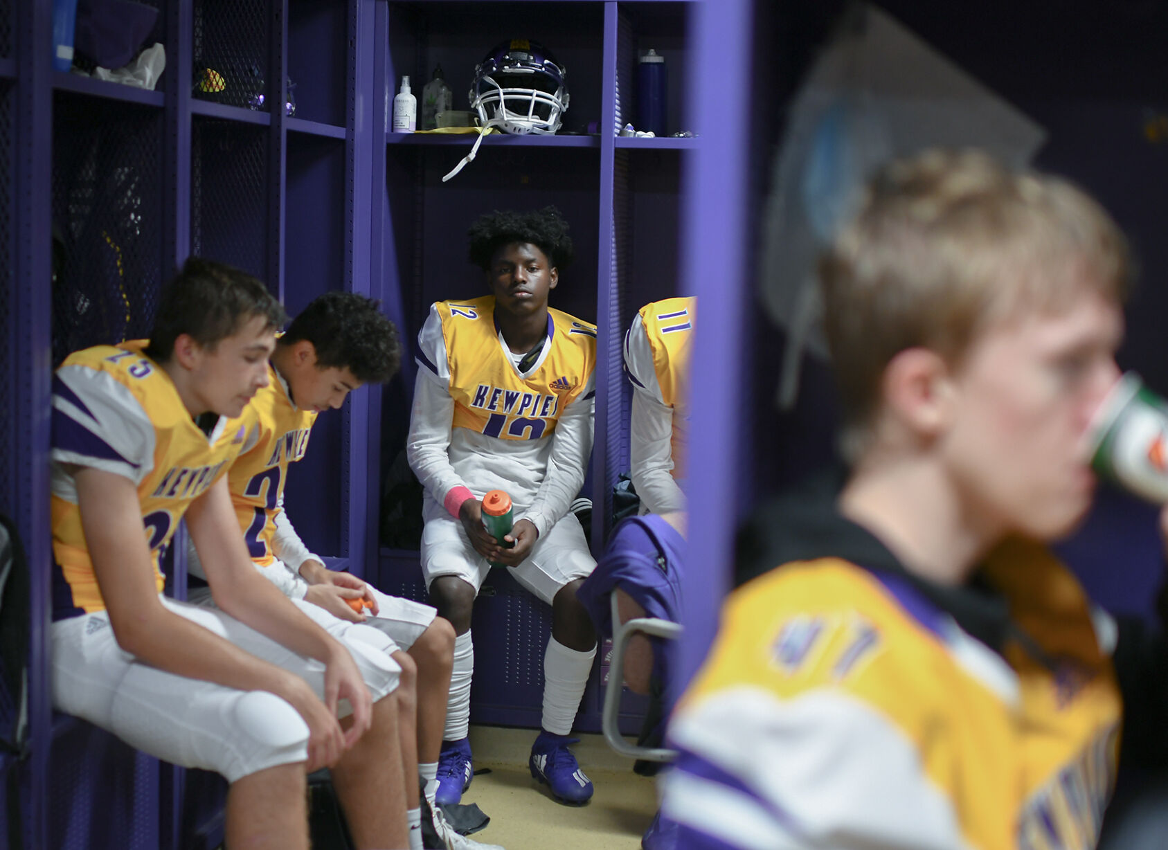 Sophomore Tione Milo sits in the locker room before